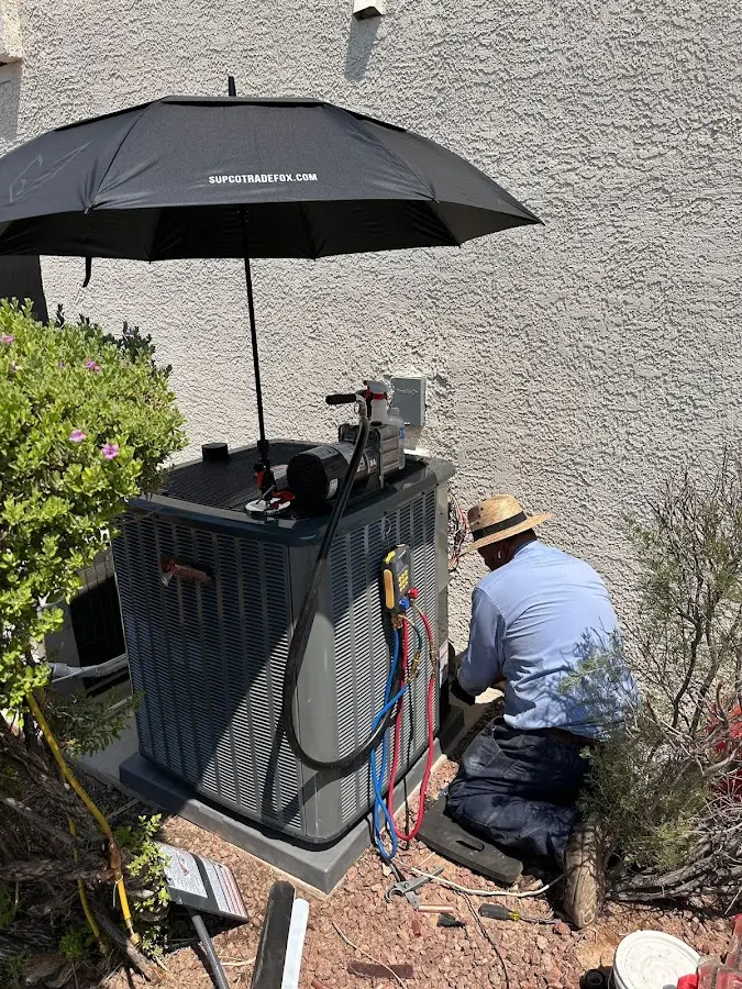 HVAC technician performing outdoor AC maintenance in Lenox